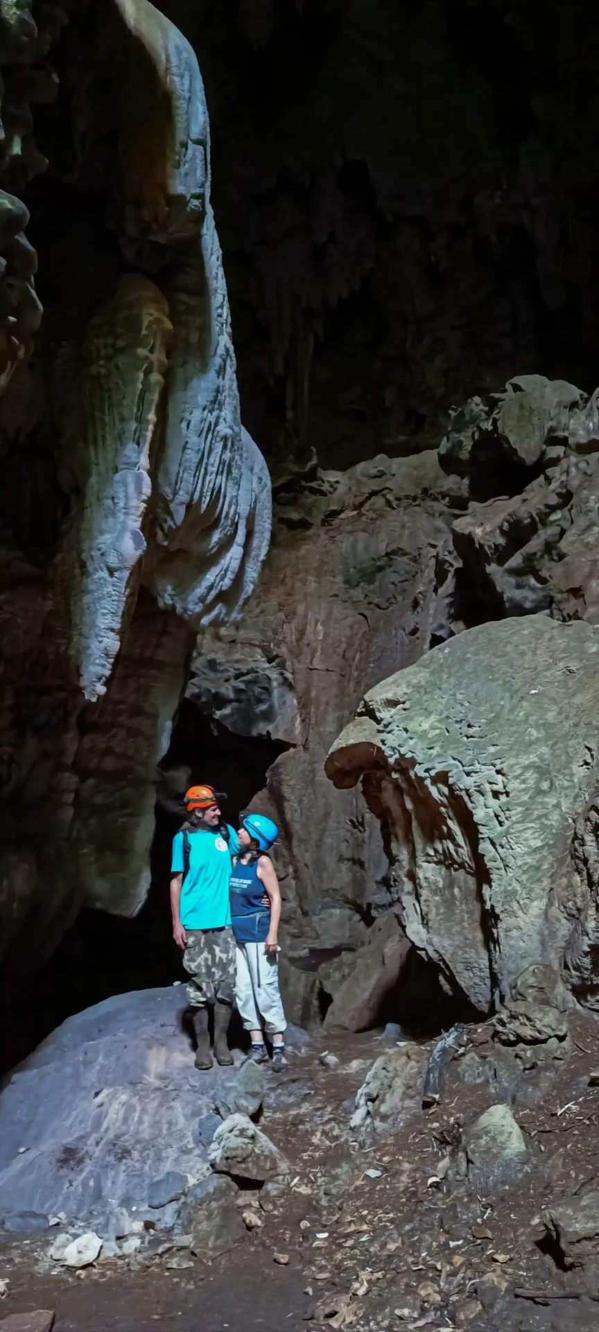 Gäste erkunden mit Helmen eine Flusshöhle
